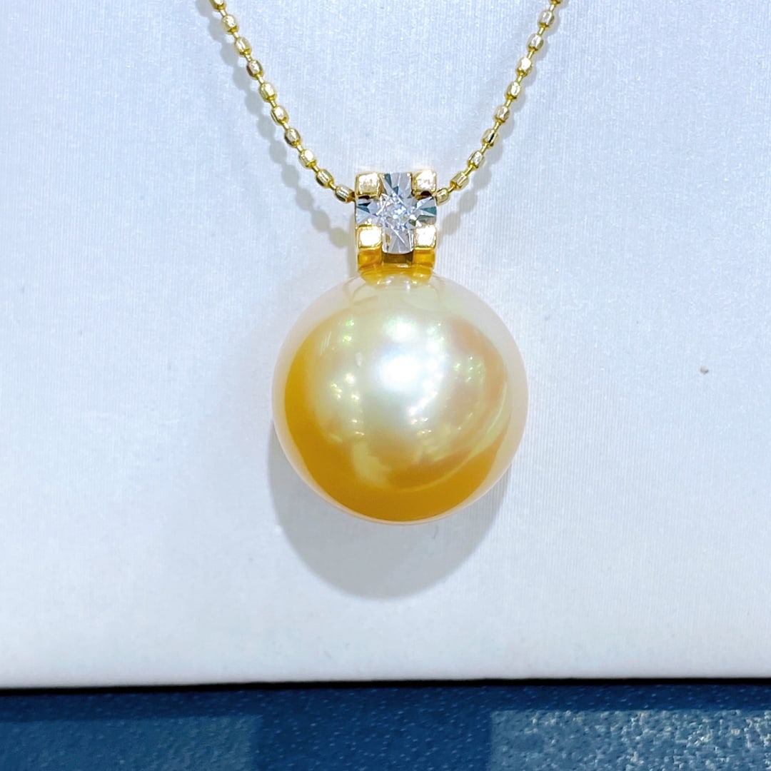 18K Gold Pearl Pendant: Title: 18K Gold Pearl Pendant Description: This 18K Gold Pearl Pendant exudes elegance with its classic design, featuring a nearly flawless, lustrous pearl that captures the light with every