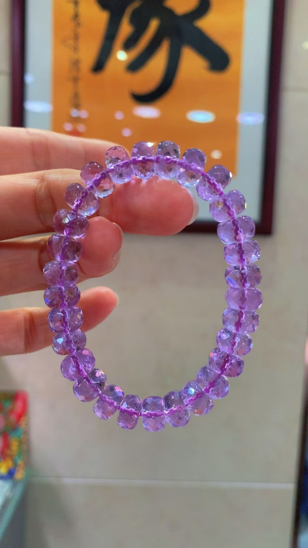 Amethyst Bracelet: Title: Amethyst Bracelet Description: This amethyst bracelet radiates with a captivating brilliance, reminiscent of shimmering diamonds. Each bead is meticulously cut to showcase a full, rounded textu