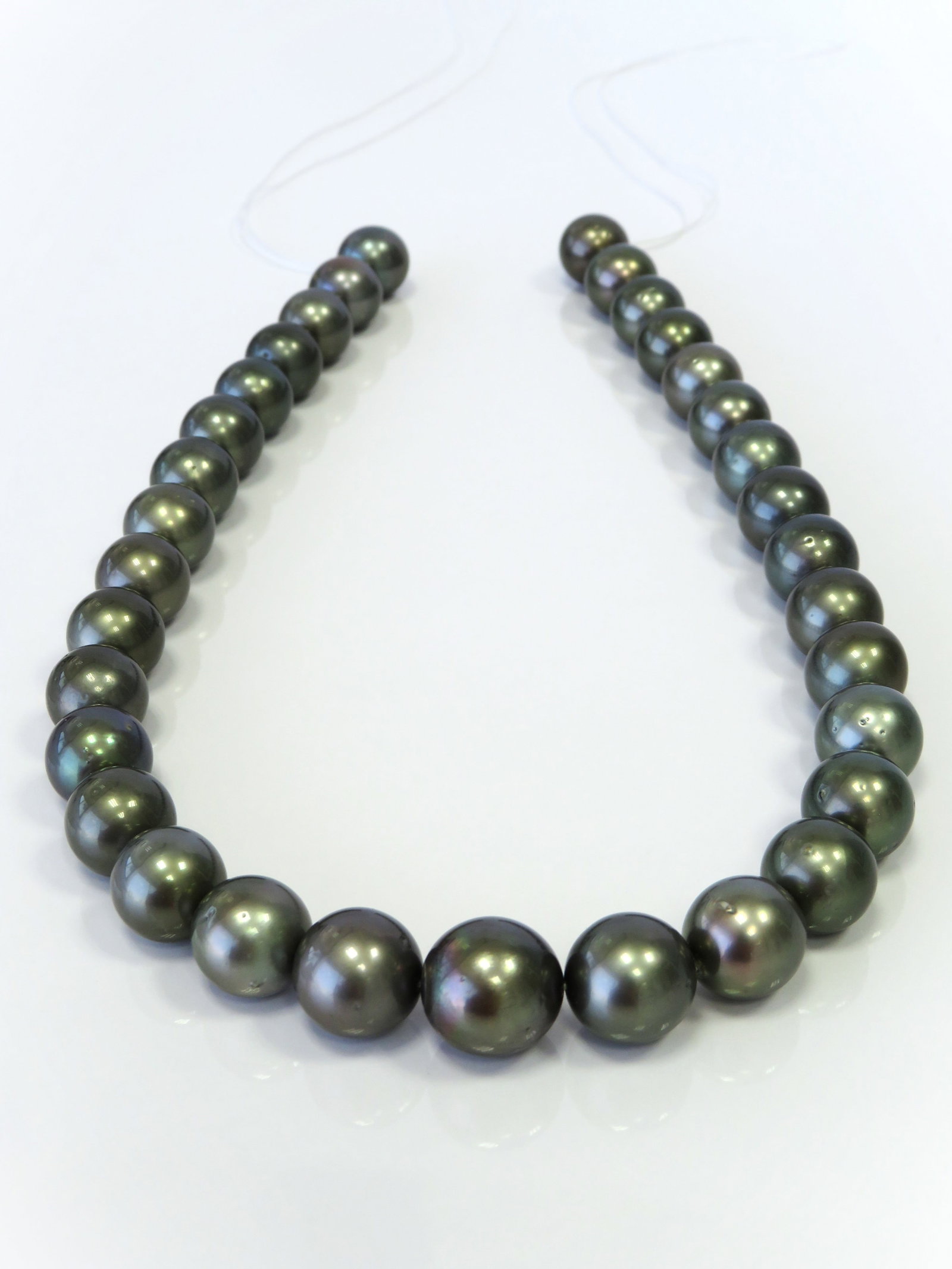 12-14mm Round Medium Dark Tahitian Pearl Necklace Strand: Title: 12-14mm Round Medium Dark Tahitian Pearl Necklace StrandDescription:AA-Grade High luster Medium Dark Round, with minimal spots/blemishes, 33 pearl pieces, 18 inches long hand-knotted with 14k