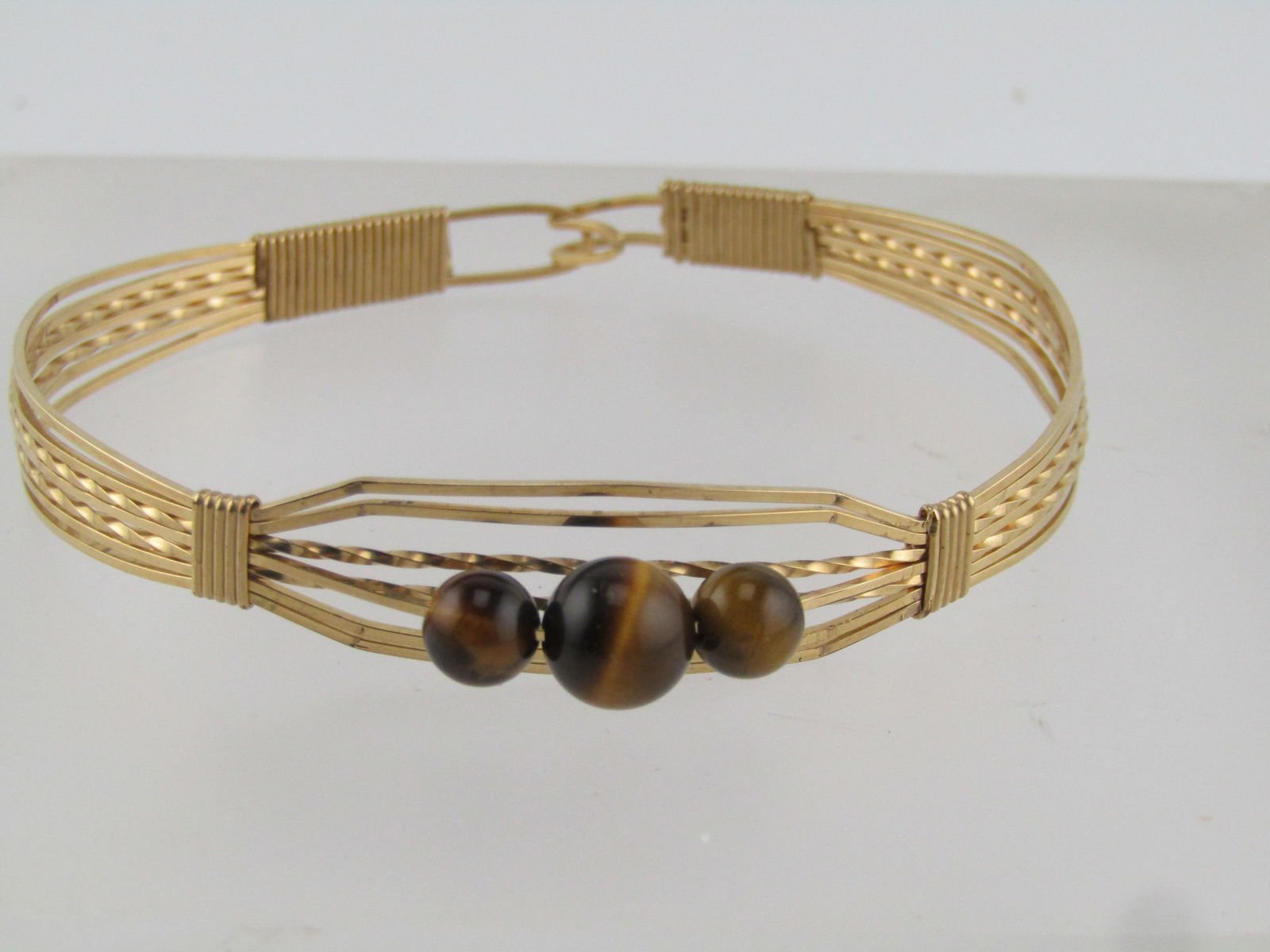 Vintage Wrapped Cuff Bracelet, Tiger's Eye, 14kt G.F, 7", 1980's: Title:Vintage Wrapped Cuff Bracelet, Tiger's Eye, 14kt G.F, 7", 1980'sDescription:Vintage Wrapped Cuff Bracelet, Tiger's Eye, 14kt G.F, 7", 1960's-1980's. This has three tiger's eye beads at the