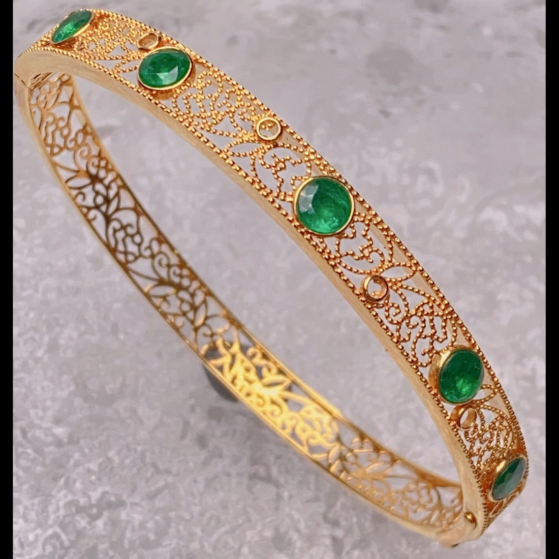 14K GOLD 2.11 CT VIVID GREEN NATURAL EMERALD BANGLE: Title:14K GOLD 2.11 CT VIVID GREEN NATURAL EMERALD BANGLEDescription:Ref:230528647Gold Content:14K GoldMain Gemstone:EmeraldShape:RoundCarat Weight:2.11ct Color:Vivid GreenTreatment:NaturalCut