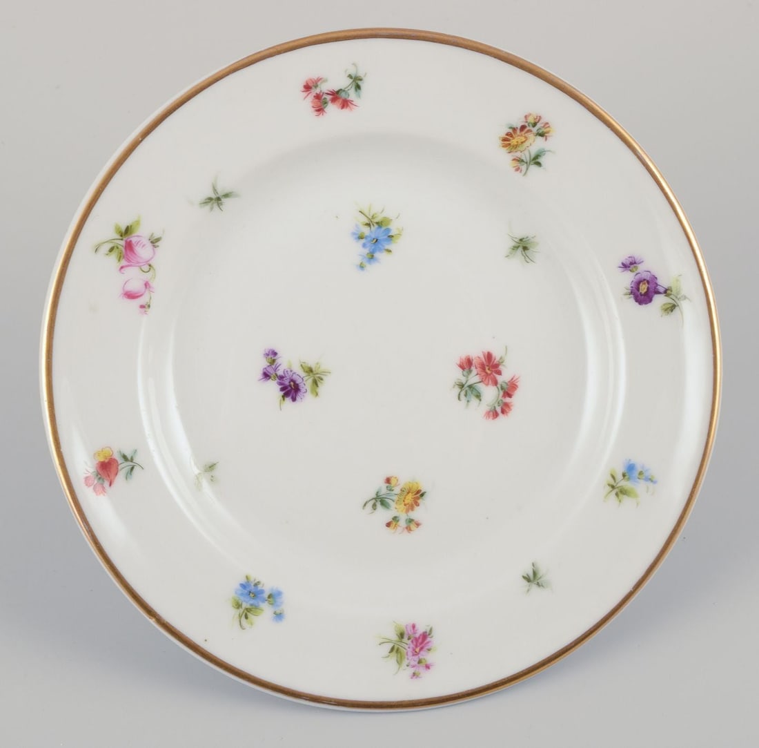 Six small porcelain plates. Hand-painted with polychrome floral motifs and gold rims. - 6