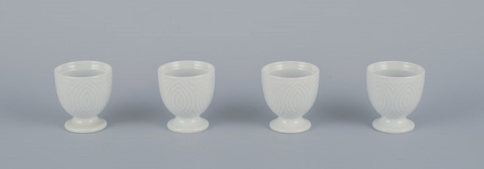 Axel Salto for Royal Copenhagen. Four egg cups in white porcelain. Circa 1960s.: Title: Axel Salto for Royal Copenhagen. Four egg cups in white porcelain. Circa 1960s. Description: Axel Salto for Royal Copenhagen. Four egg cups in white porcelain. Dating: Circa 1960s. Designed by