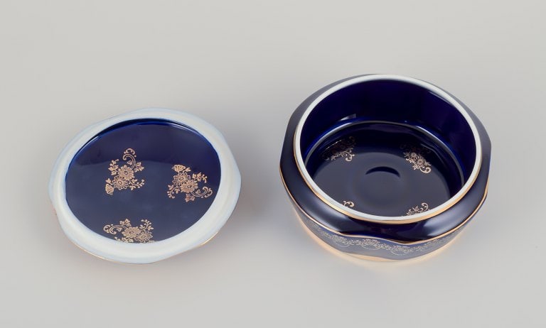 Limoges, France. Two lidded porcelain jars decorated with 22-karat gold leaf and featuring a - 7