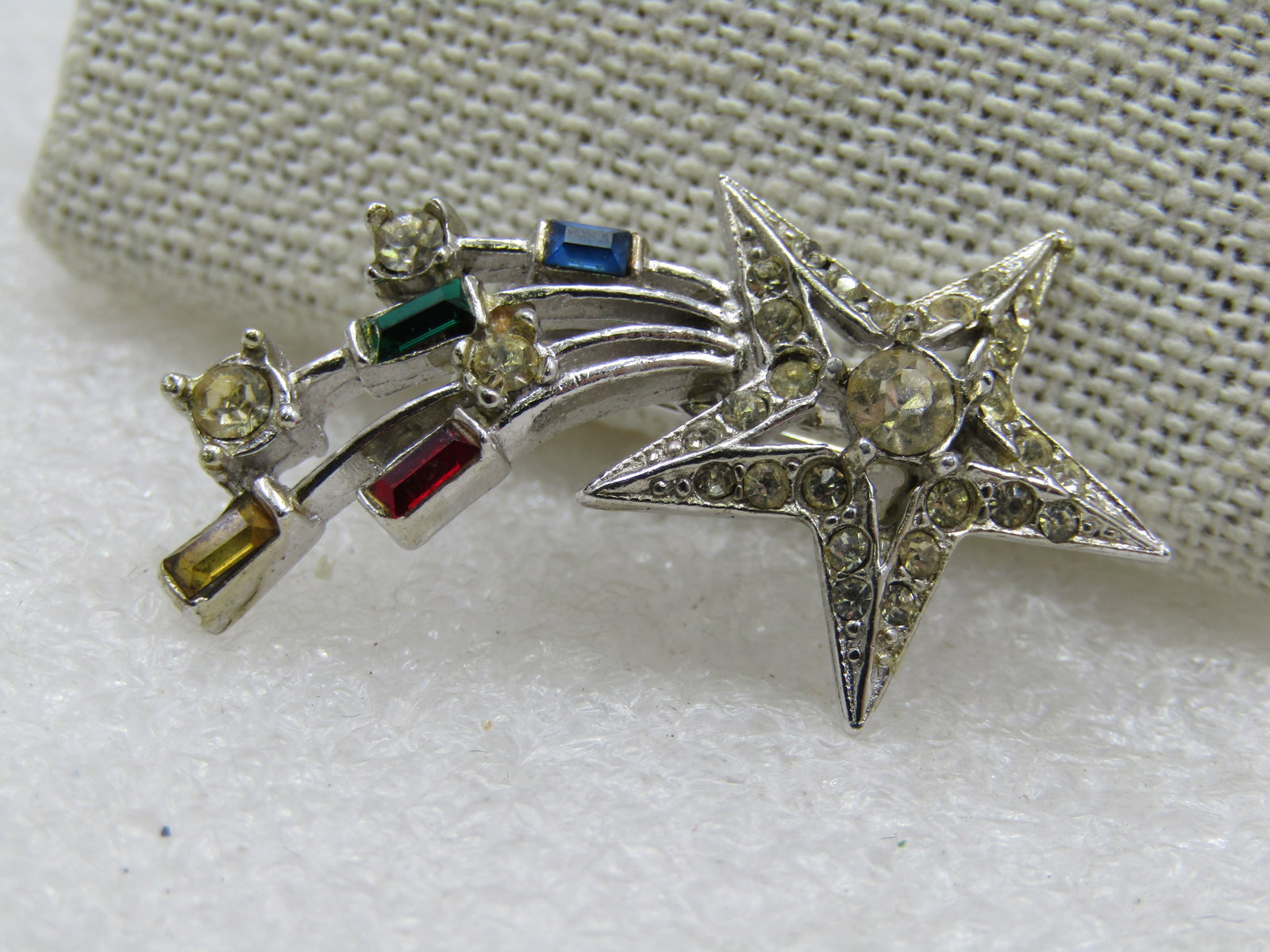 Vintage Shooting Star Rhinestone Brooch, 1940's-1950's, 1.5": Vintage Shooting Star Rhinestone Brooch, 1940's-1950's, 1.5" by 3/4". Sivler tone with clear rhinestones in the star and red, yellow, blue baguettes in the trails with round clear stones. Not signed b