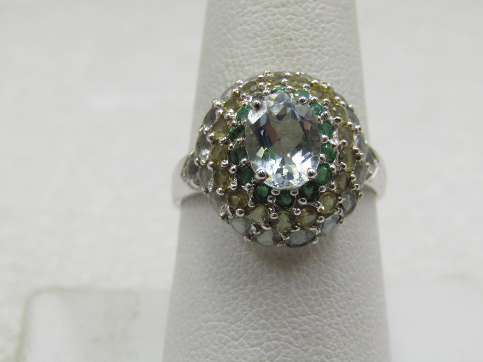 Sterling Topaz CZ Halo Ring, Sz. 8.5: Sterling Topaz CZ Halo Ring, Sz. 8.5. The main stone is appx. 7.9mm by 6mm, light blue and sits highest on the ring It has three rows of stone, each row gets wider as it moves from the main stone.