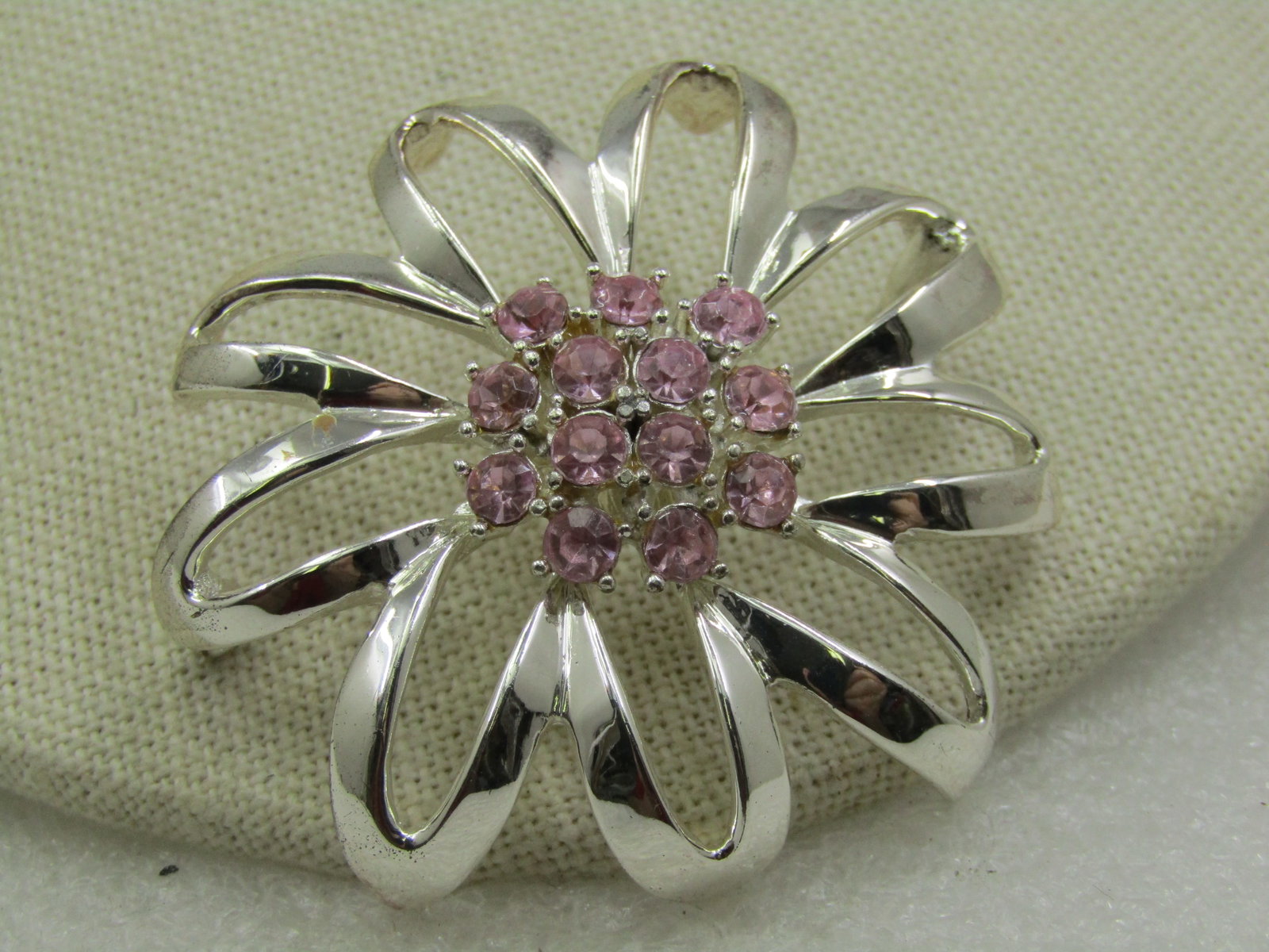 Vintage Pink Rhinestone Mod Blossom Brooch, 1960's-1970's, 2": Vintage Pink Rhinestone Mod Blossom Brooch, 1960's-1970's, 2". Silver Tone smooth metal that curves downward toward the outer petals with open petals in the center and a cluster of pink rhinestones in
