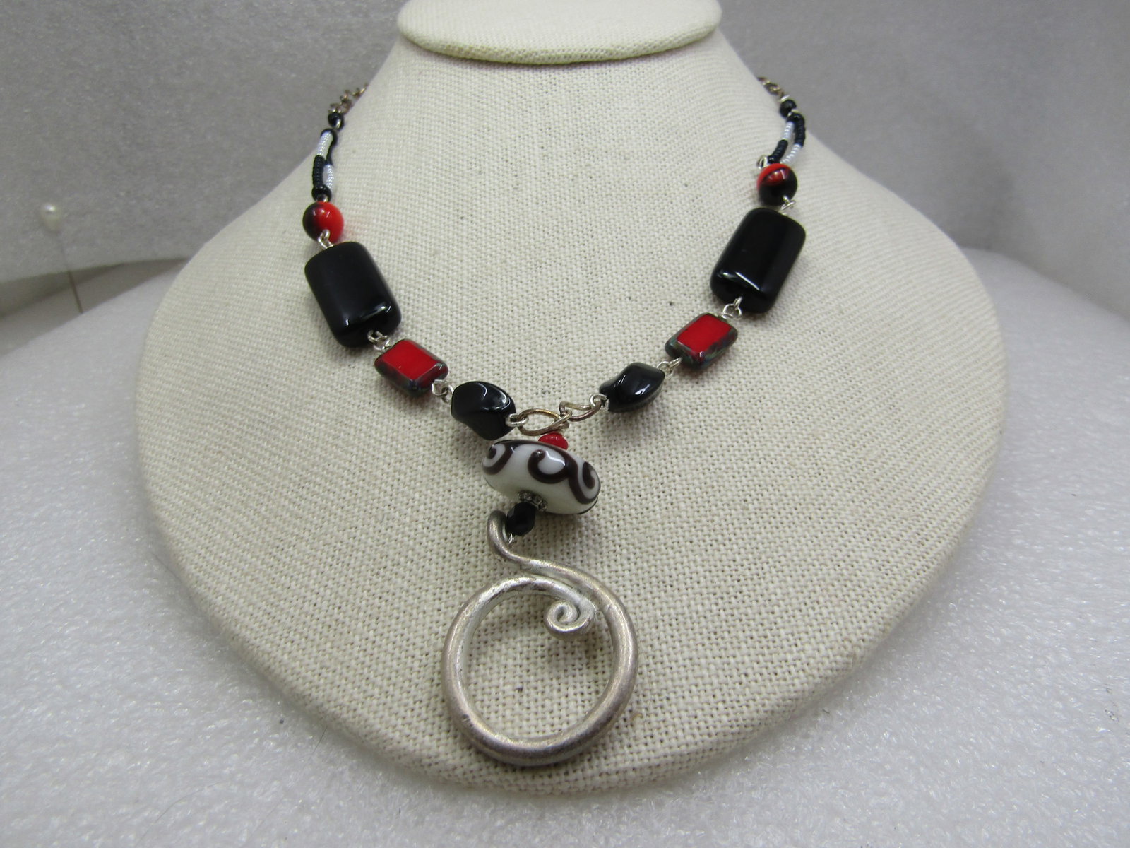 Vintage Red, Black, White Glass Beaded Necklace, 22": Vintage Red, Black, White Glass Beaded Necklace, 22". This has a coiled silver tone and black and white glass swirled bead drop from a 22" chain that is made up of black and red and black and white be
