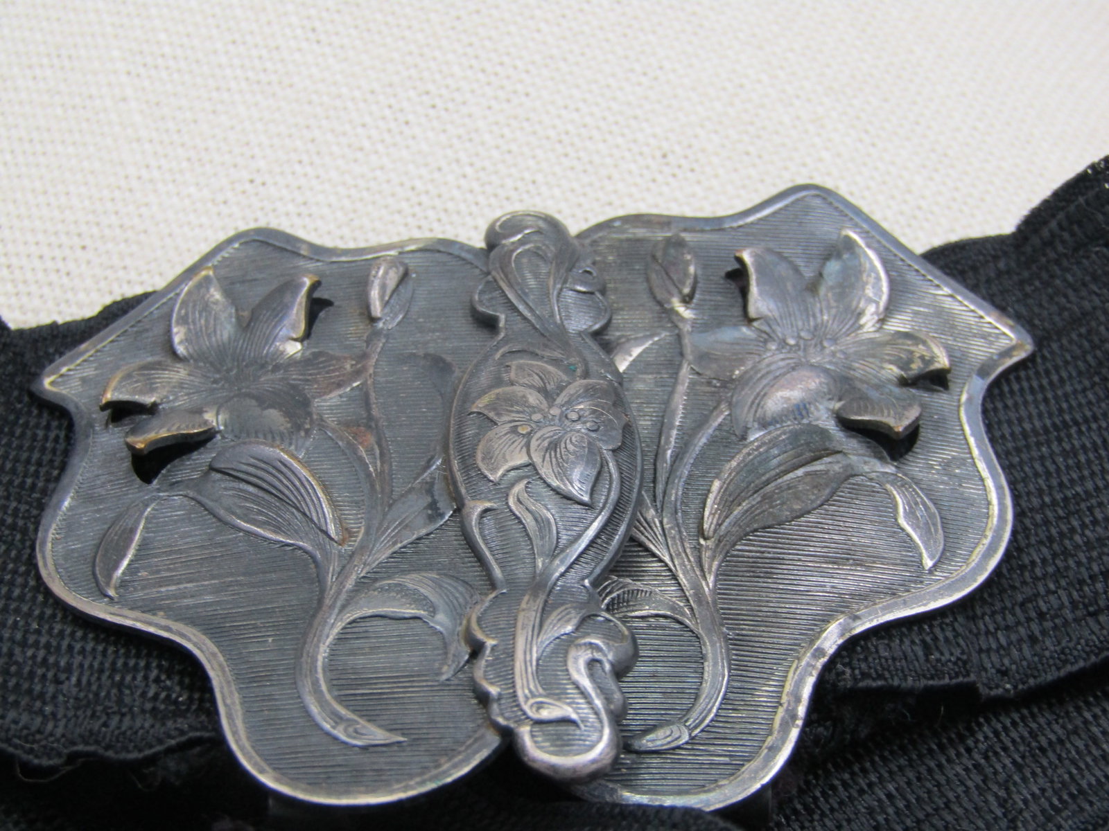 Art Nouveau Lily Belt Buckle with Black Sash/Belt, 33": Art Nouveau Floral Belt Buckle with Black Sash/Belt, 33". The belt is 1.5" wide. The buckle is two lily blossoms that have four of the petals with cut-out edges that sit up from the buckle. They