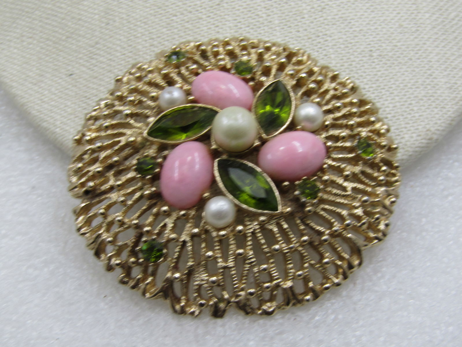 Vintage Pink, Faux Pearl, & Green Rhinestone Brooch, 2.25", Sarah Coventry, 1970's: Vintage Pink, Faux Pearl, & Green Rhinestone Brooch, 2.25", Sarah Coventry, 1970's. Gold tone and dome with an open filigree chunky design with a center 7mm faux pearl and three smaller pearls that ar