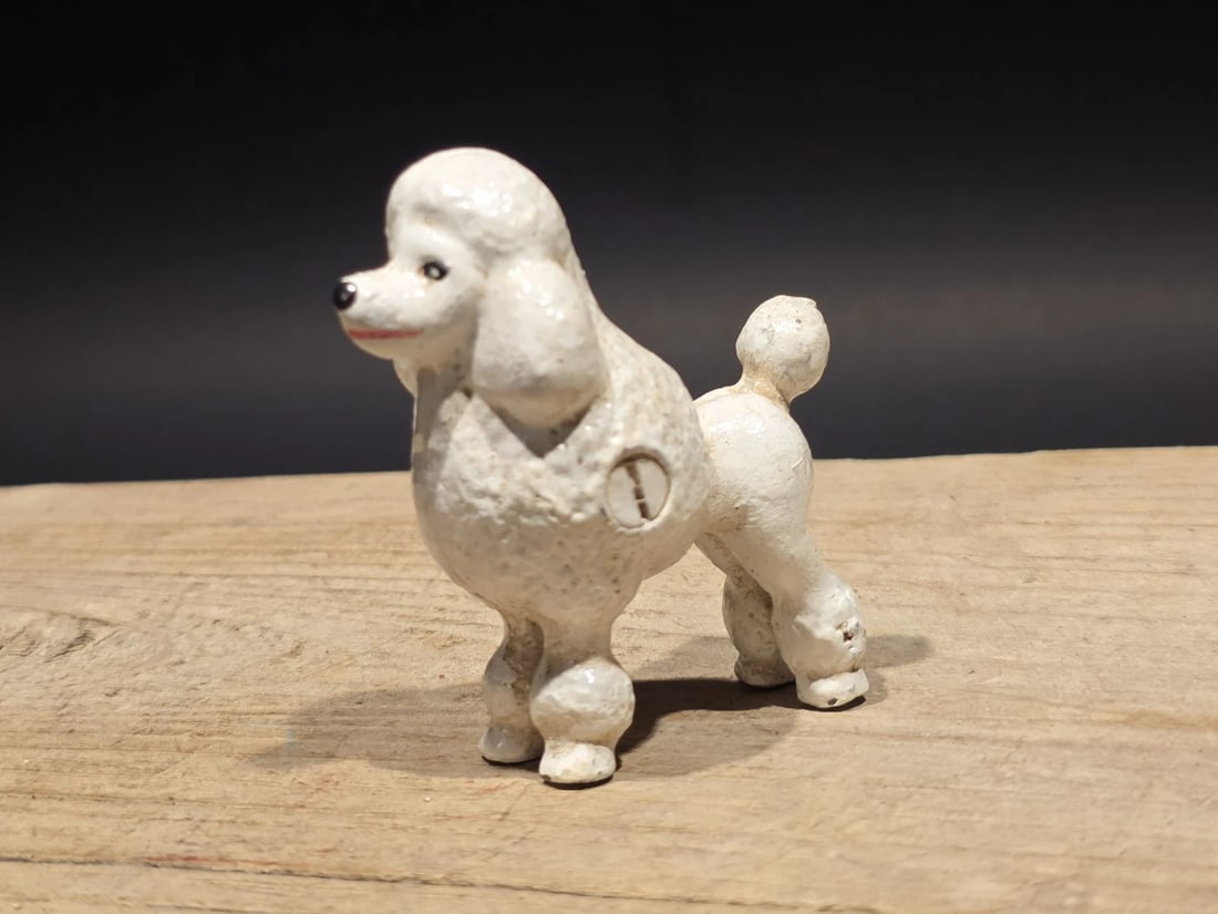 Cast Iron Poodle Dog Figurine White Poodle Statue: Cast iron poodle dog figurine depicting the classic standard poodle grooming style with clipped coat and rounded tail. Dog breed figurines like this became popular decorative pieces during the mid-20t
