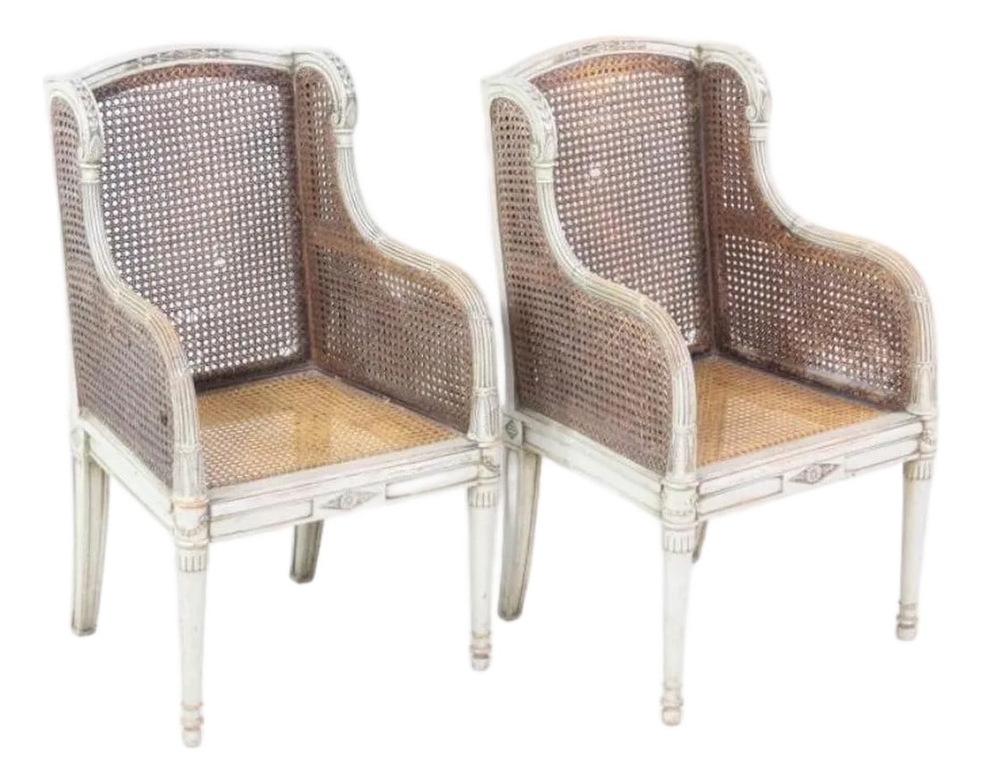 A Pair of Louis XVI 18th Century Style French Childrenâ"Â™s Bergere Chairs: Pair of Louis XVI Style Wood Children's Chairs. These matching diminutive chairs have enclosed caned seats, armrests, & backs and carved frames with patinaed gray paint. Dimensions are 29 in h x 17 in
