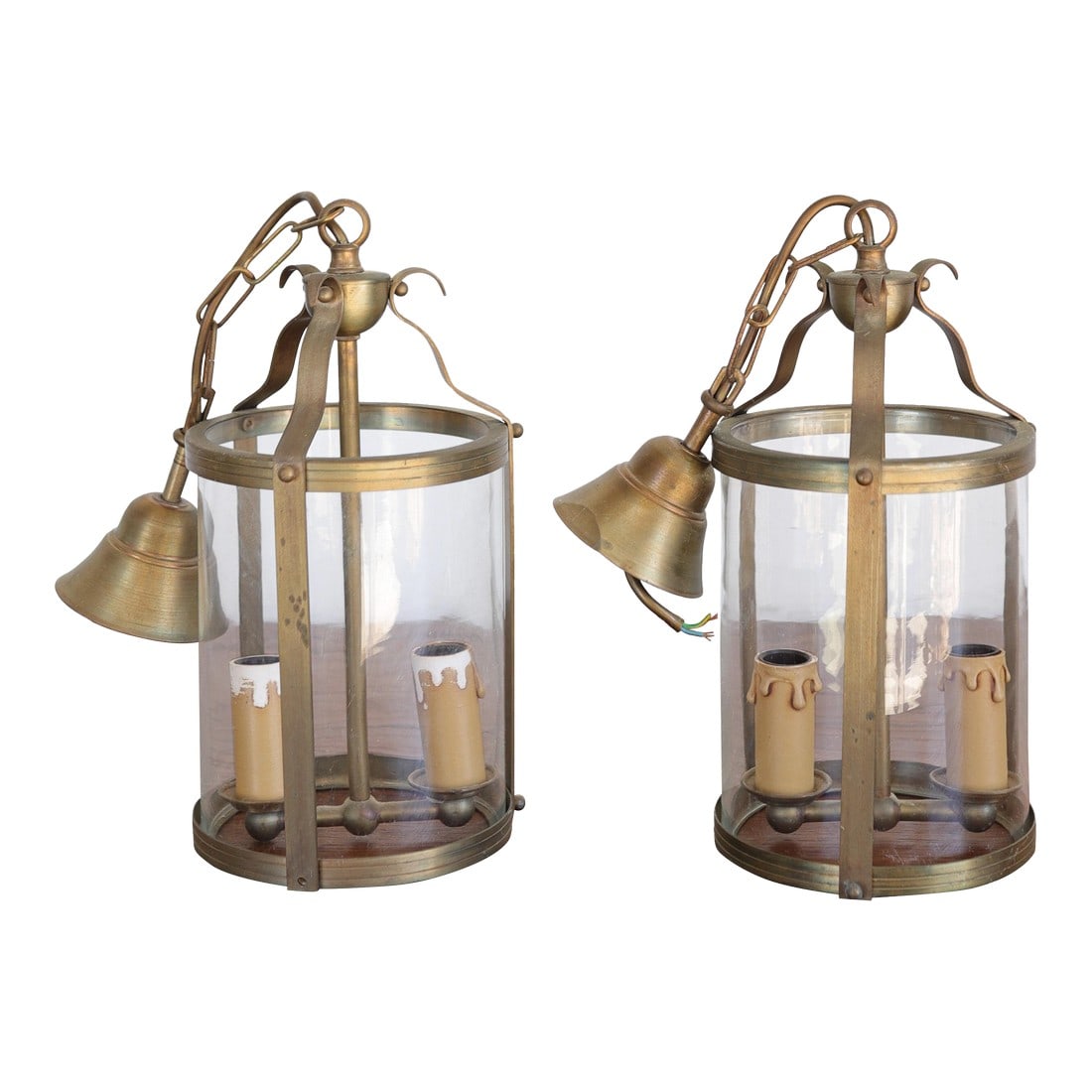 Late 19th Century Pair of French Brass Lanterns / Pendant Lighting: Elegant and timeless, this pair of French brass lanterns brings classic continental charm to any interior or covered outdoor space. Each lantern features a gracefully curved frame in warm, aged brass