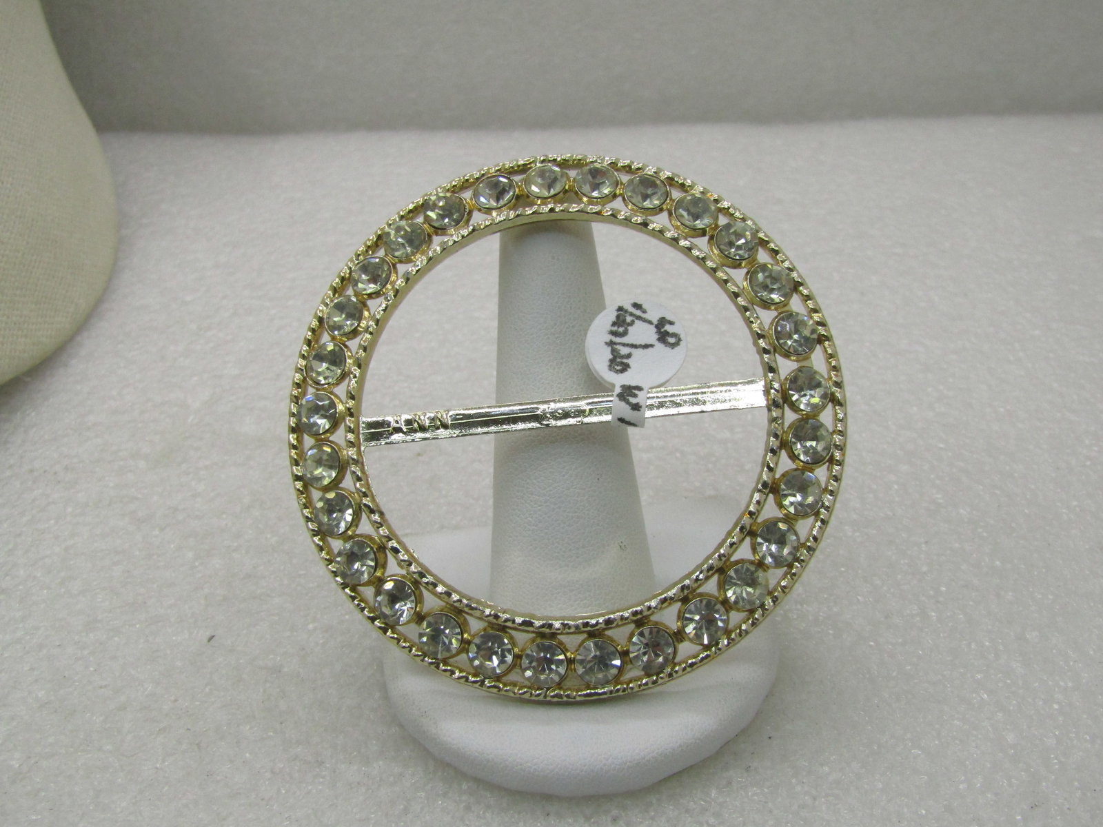 Vintage Rhinestone Oval Sash Buckle, 2,75" Round, signed ANN. Gold tone: Vintage Rhinestone Oval Sash Buckle, Gold Tone, 2.75" round With rhinestones in the angled frame around the entire buckle. 5" Oval, Silver tone with rhinestones in two rows that make up the. ANN is