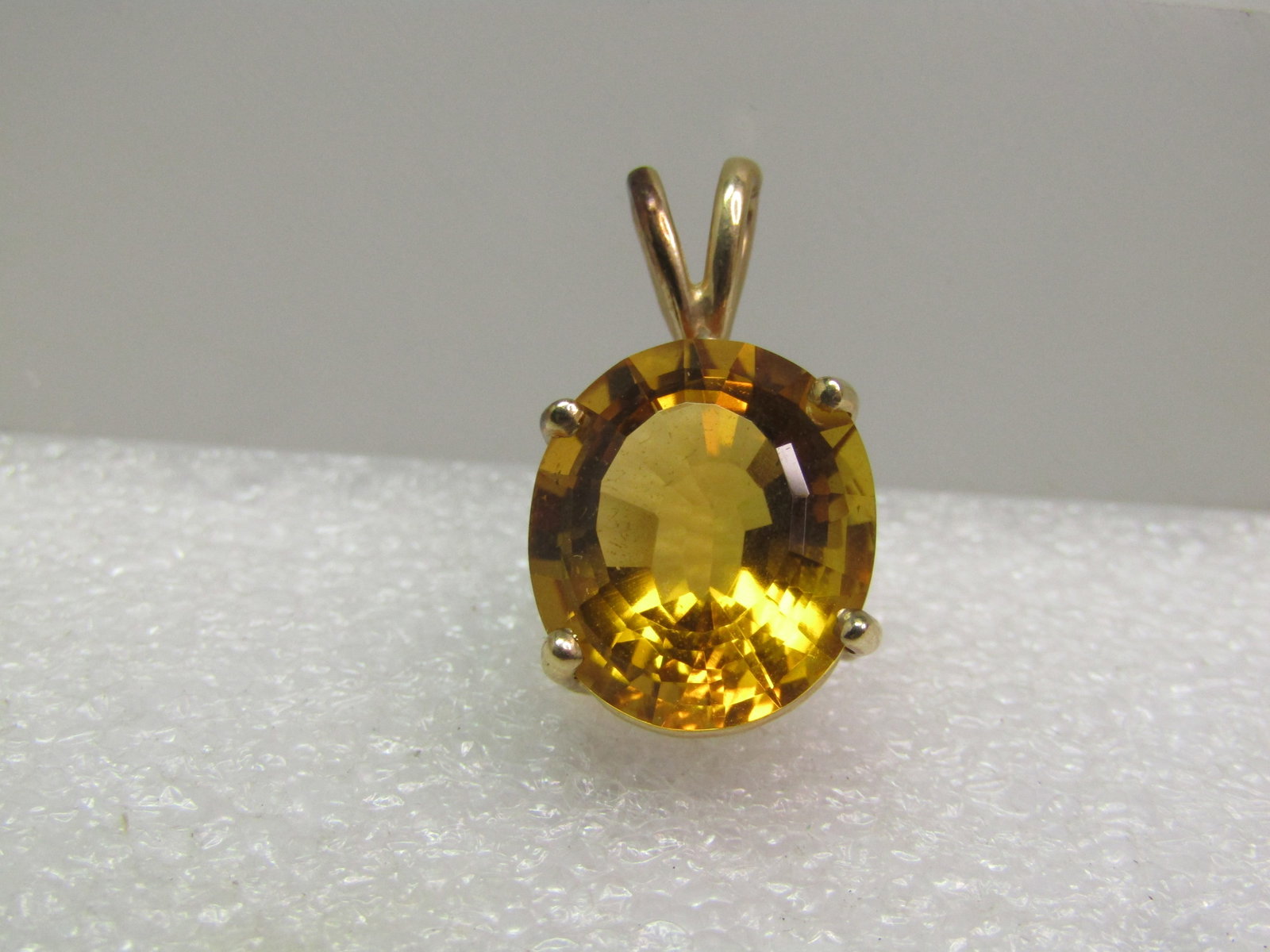 Vintage 10kt Yellow Topaz Oval Pendant, 1980's-1990's: Vintage 10kt Yellow Topaz Pendant, 1980's-1990's. Estate had this listed as 14kt - tests mildly at 14kt and strongly at 10kt. Weight is appx. 3.22 grams. The stone is appx. 13mm by 12mm with a