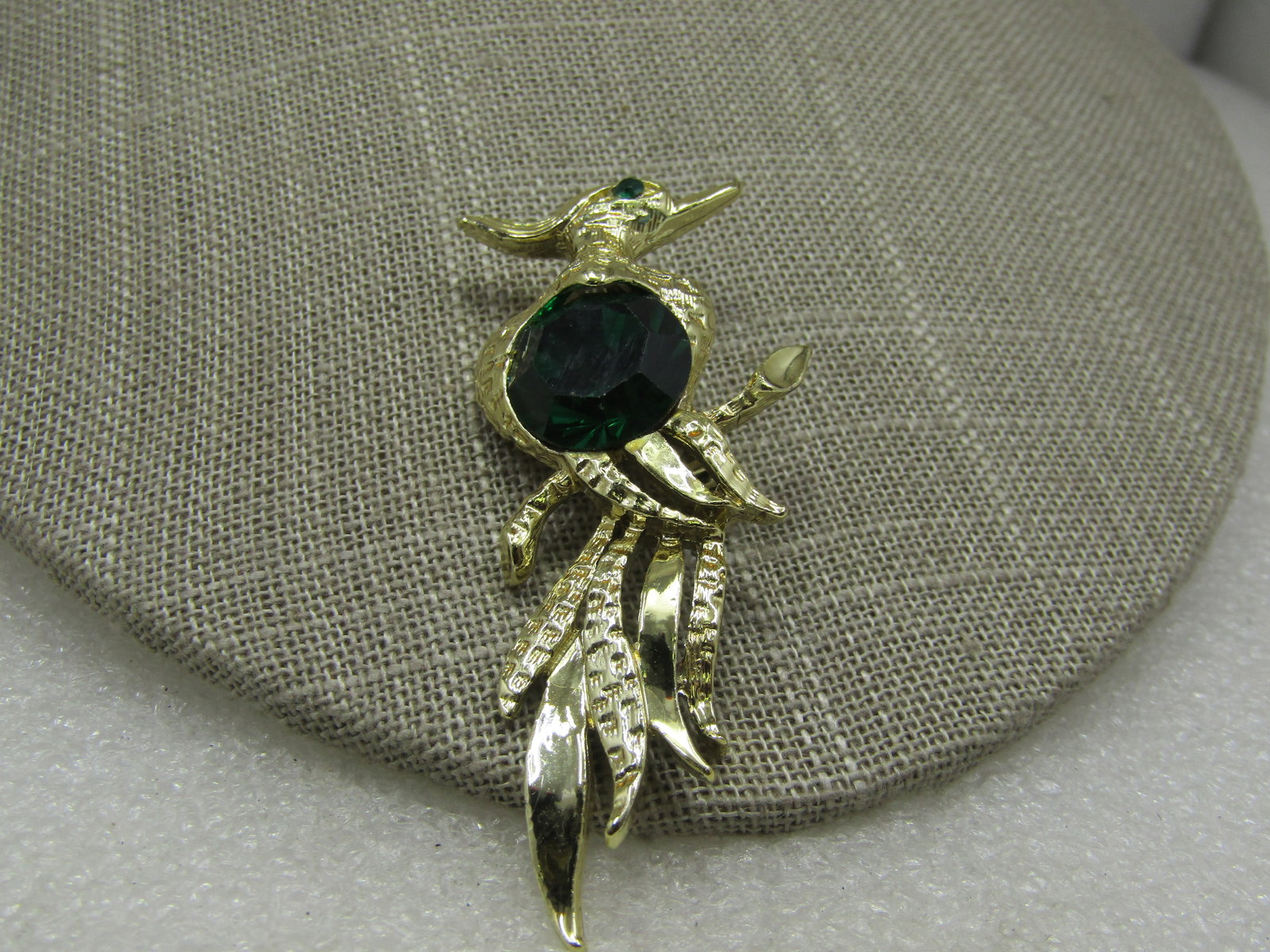 Vintage Parrot Brooch, Large Green Glass Stone, 2.5": Vintage Parrot Brooch, Large Green Glass Stone, 2.5" by 1-1/8". Large round faceted dark green stone in the center that is appx. 14mm wide with a green rhinestone eye. Textured and smooth feathers. 19