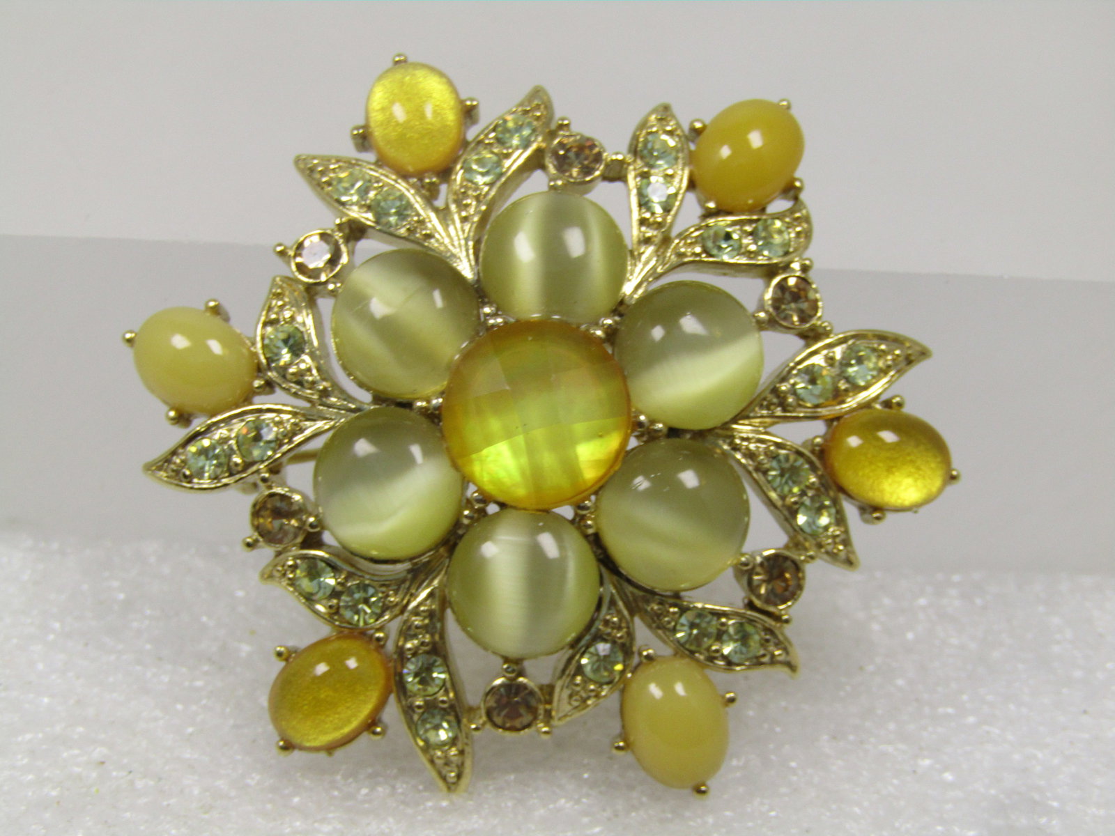 Vintage Yellow Rhinestone & Cateye Brooch, 1970's-1980's: Vintage Yellow Rhinestone & Cateye Brooch, 1970's-1980's. This is domed with a honeycomb stone in yellow on top - that is an acrylic stone. There are yellow cateye stones that are glass and oval