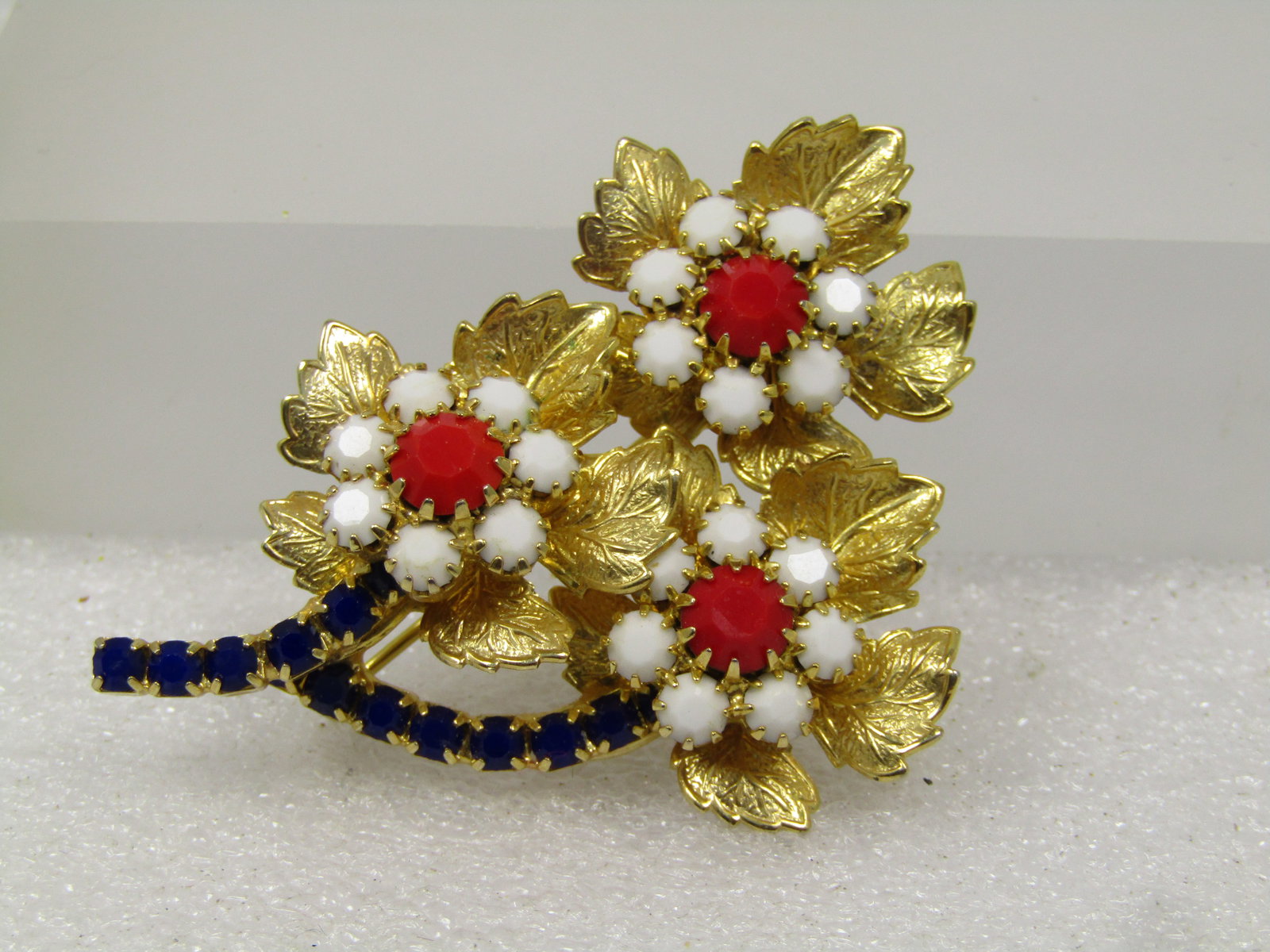 Vintage Red/White/Blue Blossom Stem Brooch, 1960's: Vintage Red/White/Blue Blossom Stem Brooch, 1960's. Great for patriotic holidays too. Gold tone with three blossoms and a center of milk glass w hite and red stones and blue rhinestones as the