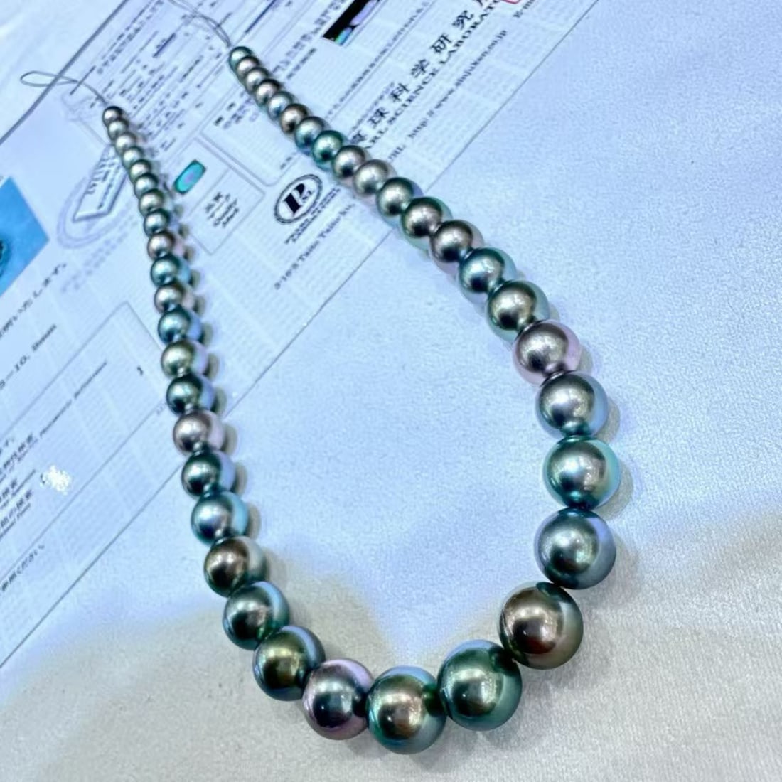 Tahitian Pearl Necklace: Title: Tahitian Pearl Necklace Description: This necklace showcases the unparalleled charm of Tahitian pearls, with a shiny light mixed color tone adding a unique touch of elegance. The pearls'