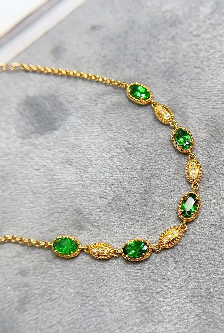 18K Gold Tsavorite Garnet Bracelet: Title: 18K Gold Tsavorite Garnet Bracelet Description: This exquisite bracelet embodies the essence of luxury, crafted in 18K gold and set with a rich, spicy green tsavorite. Its glassy texture and vi