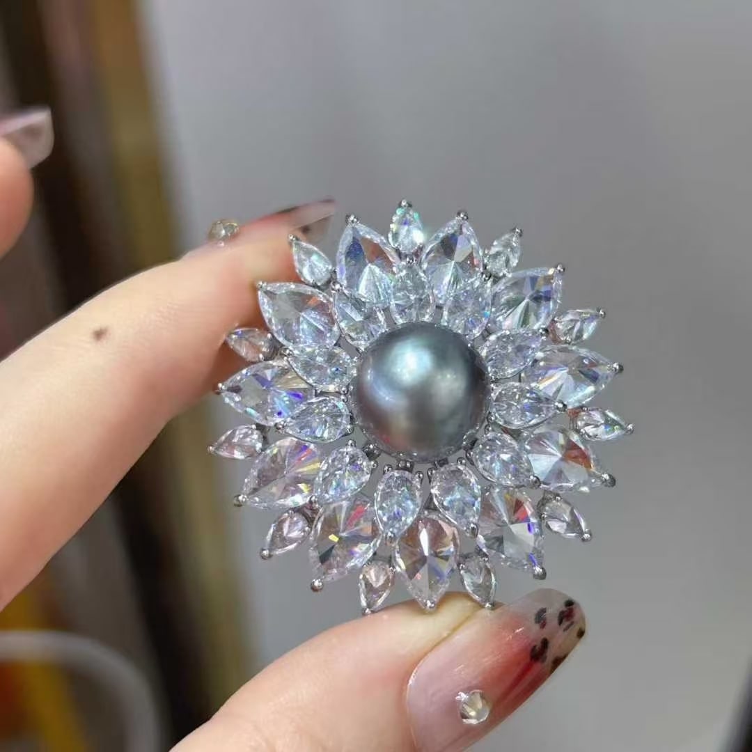 Alloy Seawater Pearl Brooch: Title: Alloy Seawater Pearl Brooch Description: This brooch is delicately paired with a natural 11mm Tahitian pearl, showcasing a unique charm with strong luster and minor blemishes. The pearl's luste