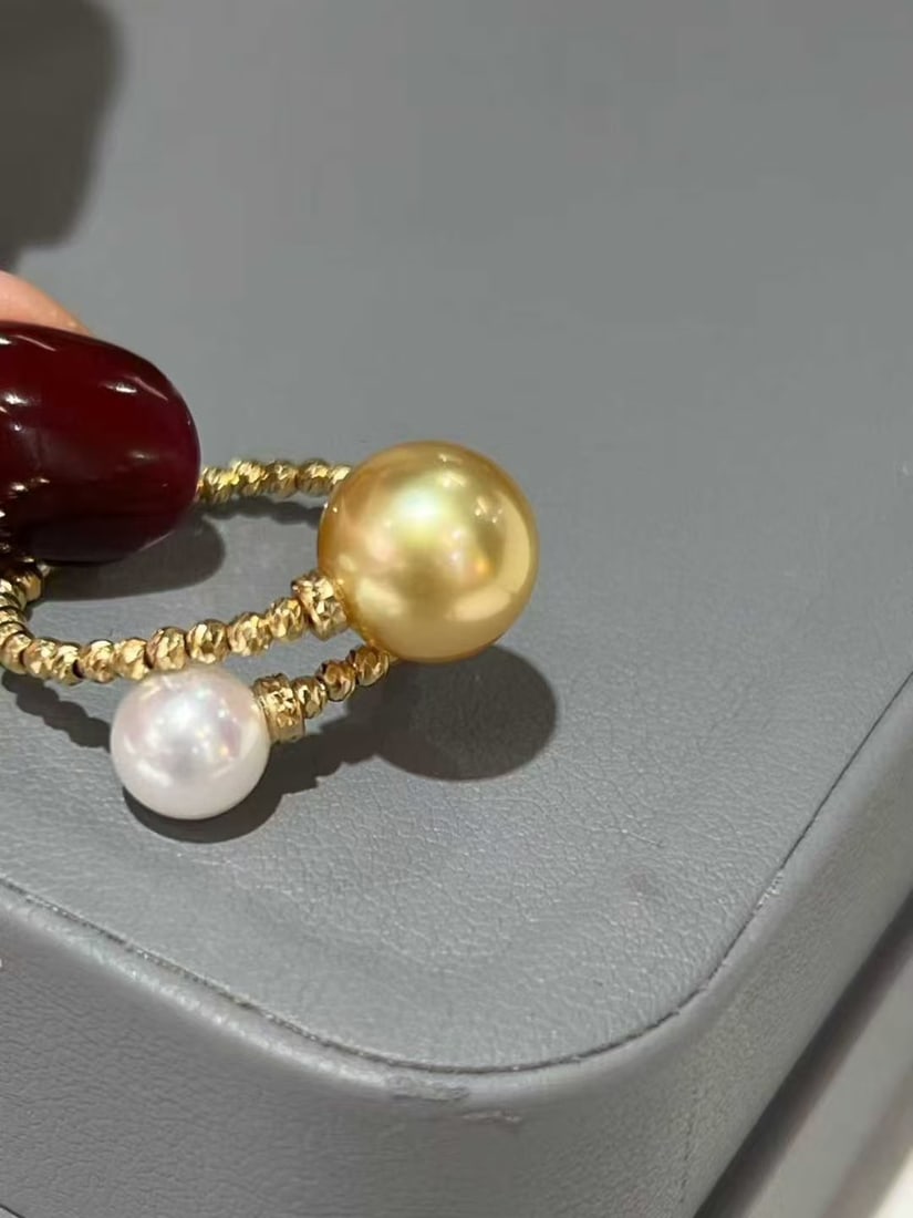 Pearl double ring: Title: Pearl double ring Description: This dual-color pearl ring, with its elegant design and exquisite craftsmanship, becomes the perfect choice for every wearer. It features iridescent flawless