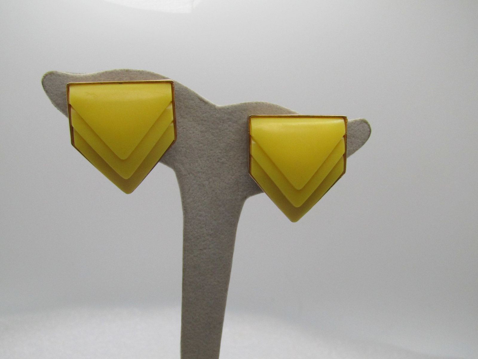 Vintage Yellow Lucite Chevron Earrings, Clip, 1960's-1970's: Vintage Yellow Lucite Chevron Earrings, Clip, 1960's-1970's. Set in gold tone solid backs of the same shape with a frame or bezel around the edges. They are appx. 1.25" tall and 1-1/8" wide. Very good