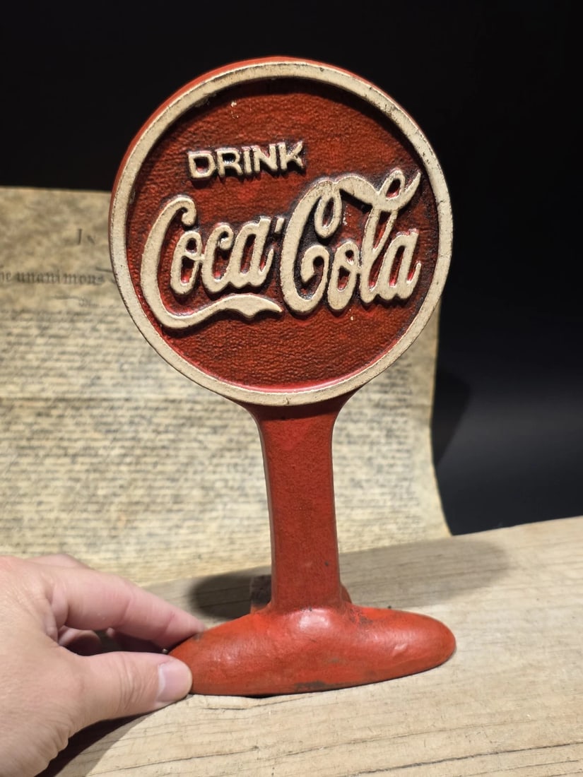 Coca Cola Cast Iron Doorstop Lollipop Sign Base Advertising: Title: 9.5" Vintage Style Coca Cola Cast Iron Doorstop Lollipop Sign Base AdvertisingDescription: 9 1/2" Tall This is a heavy, cast iron Coca-Cola "lollipop" reproduction sign base, highly popular