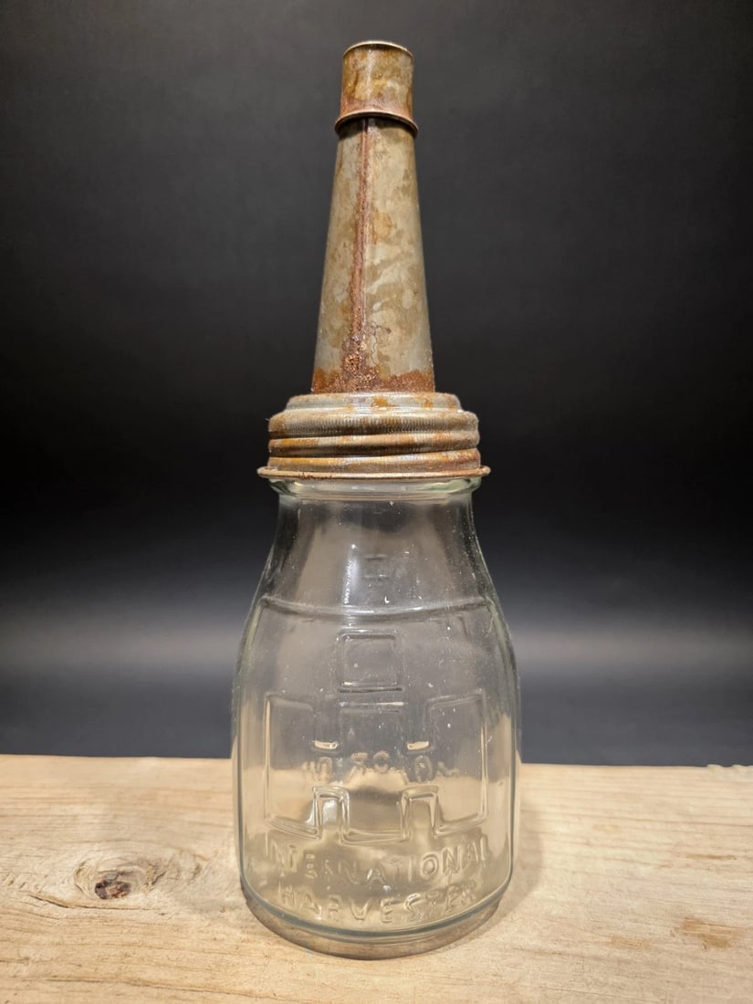 1930s Style Glass Farmall Oil Bottle w Spout: Title: 1930s Style Glass Farmall Oil Bottle w Spout Description: 3.5 W x 17 H Wonderful vintage style reproduction Farmall motor oil bottle with its spout. Such a neat reproduction glass oil bottle. W