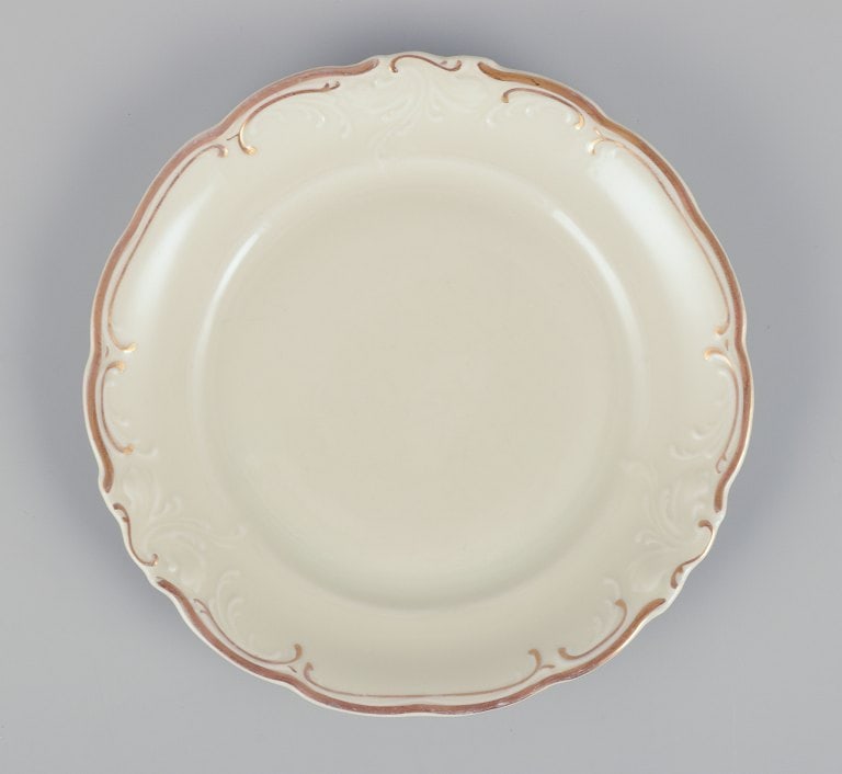 KP, Karlskrona, Sweden. A set of nine cream-colored porcelain plates with gold decoration. - 2
