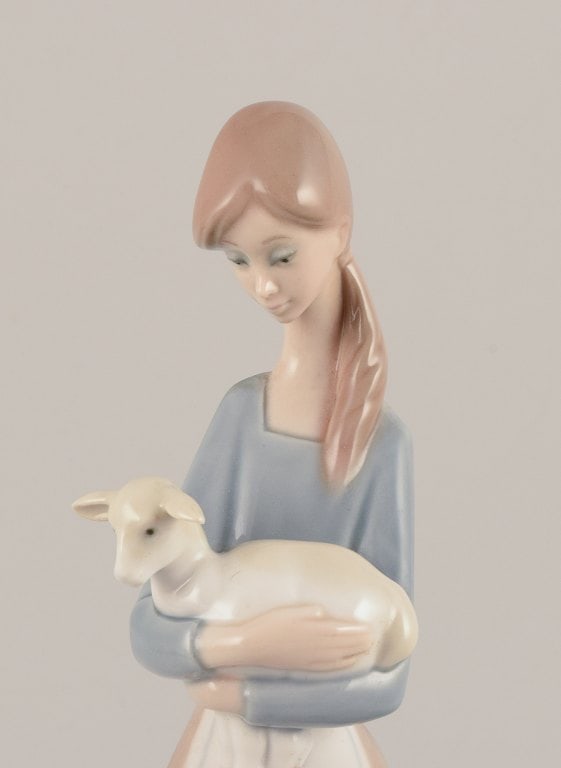 Lladro, Spain. Porcelain figurine of a standing young woman holding a lamb in her arms. - 3