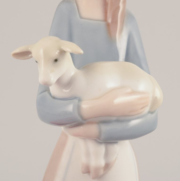 Lladro, Spain. Porcelain figurine of a standing young woman holding a lamb in her arms. - 5