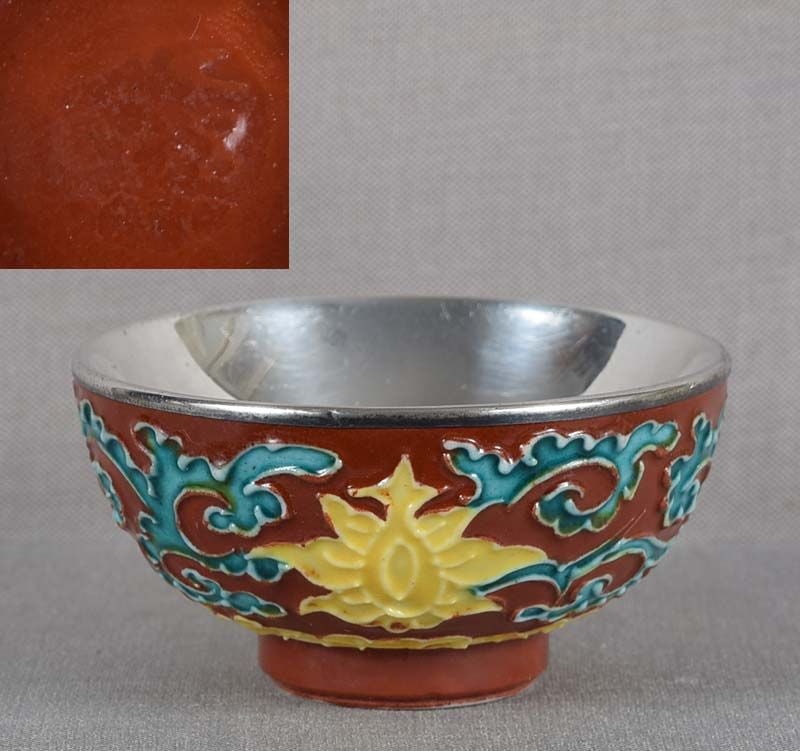19c Japanese porcelain sake cup by EIRAKU: 19th century/Meiji period Japanese porcelain sake cup with silver lining on the inside and decoration of flowering lotus flowers among scrolling vines above stylized clouds, all on tomato red backgrou