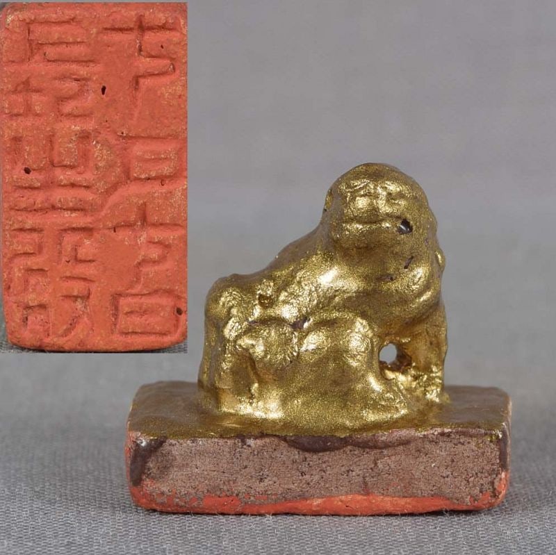 19c lacquered ceramic seal netsuke SHISHI: 19th century Japanese lacquered ceramic miniature seal netsuke modeled as shishi - Buddhist lion - sitting on a rectangular base, its head turned to its right. The impression of the seal is shown on t