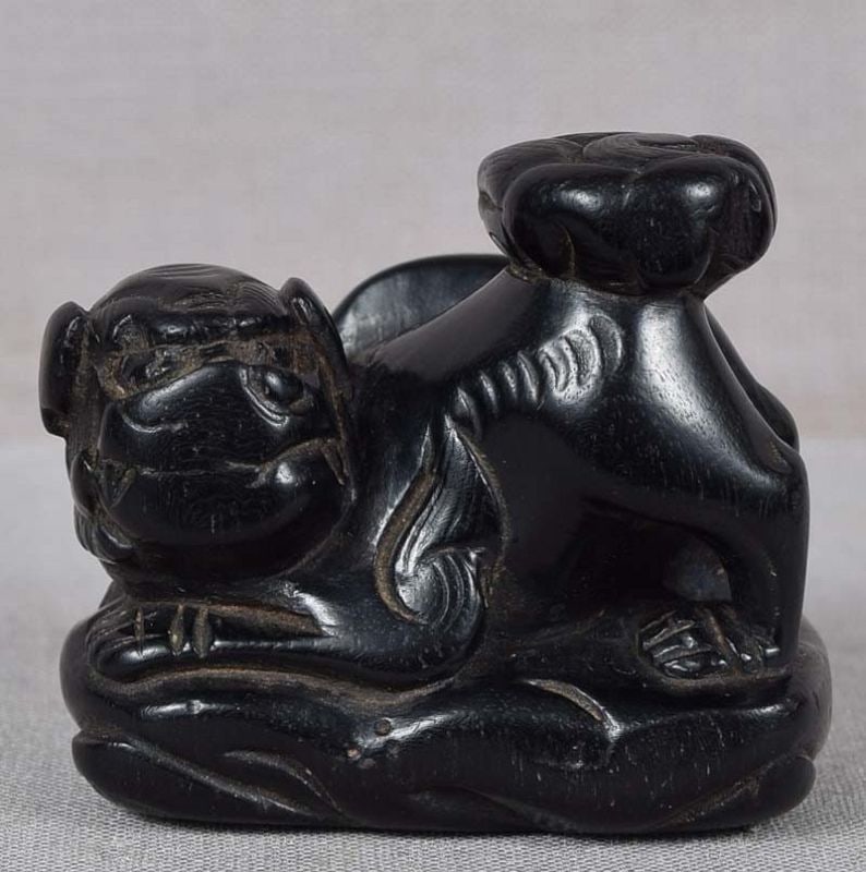 18c ebony netsuke SHISHI on rockery: 18th century kokutan (ebony) netsuke of a shishi (Buddhist lion) crouching by rockery. Strong early carving, nicely captured playful attitude of the beast, unusual raised umbrella-like bushy tail. Lar