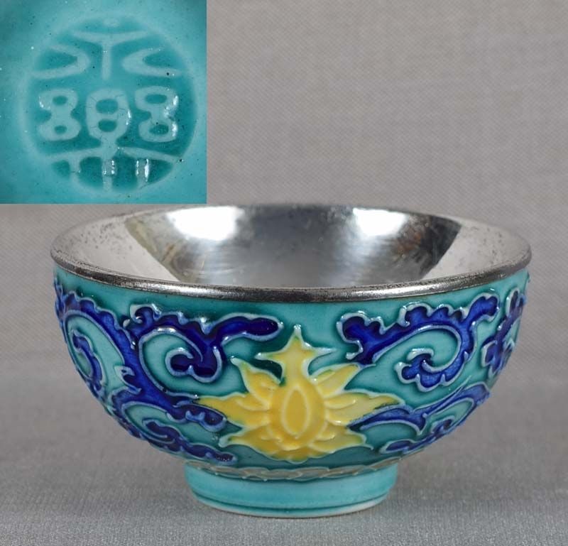 19c Japanese porcelain sake cup by EIRAKU: 19th century/Meiji period Japanese porcelain sake cup with silver liner on the inside and decoration of flowering lotus flowers among scrolling vines above stylized clouds, all on turquoise