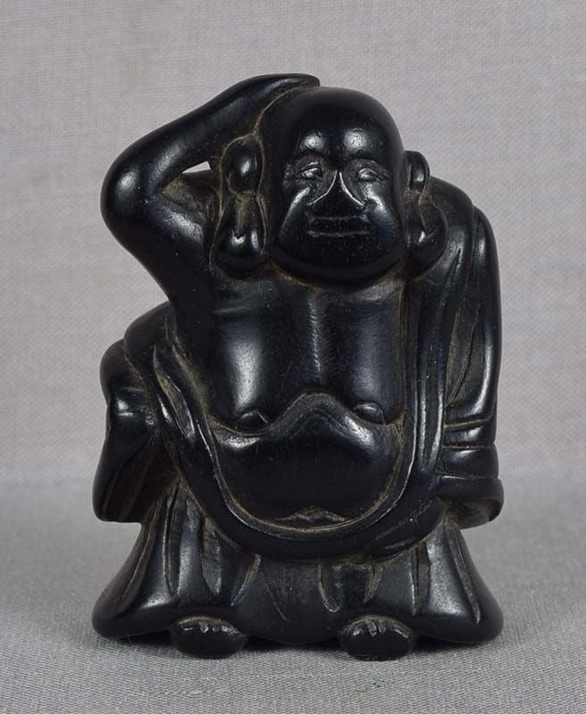 18c ebony netsuke HOTEI: 18th century kokutan (ebony) netsuke of standing Hotei, his hand raised to the top of his head. Hotei was a historical Chinese monk allegedly living in Wuyue kingdom in the 10th century and known for