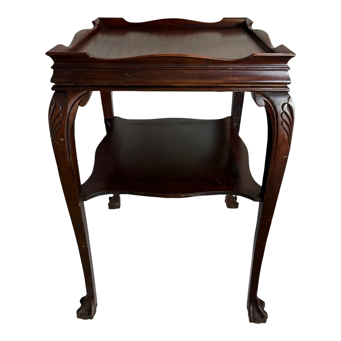1940s Chippendale Style Gallery Top Two Tiered Claw and Ball Table: This is a square two tiered table with a raised gallery top. The carvings and leg style indicates a Chippendale style with claw and ball feet. It is as stylish as it is practical and versatile