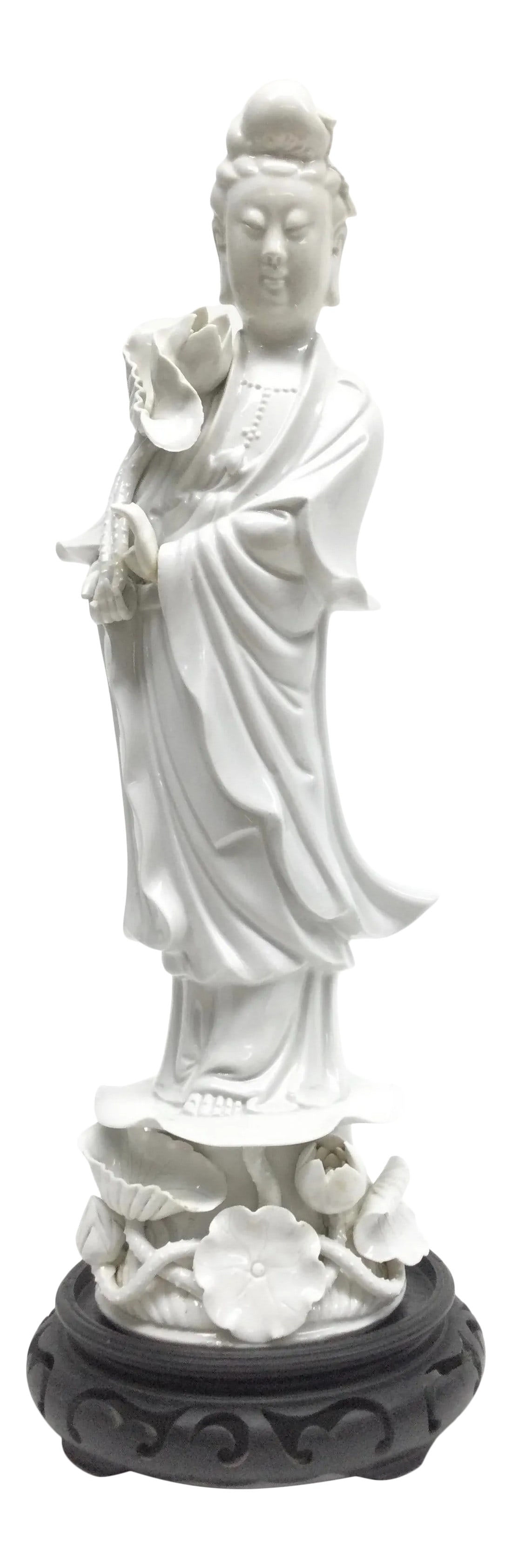 Vintage Chinese White Porcelain Guanyin: A wonderful Blanc de Chine figure of Guanyin standing with a flowing robe on a base of lily foliage. Wood base is included. In wonderful condition with only some tips of her fingers broken off. For