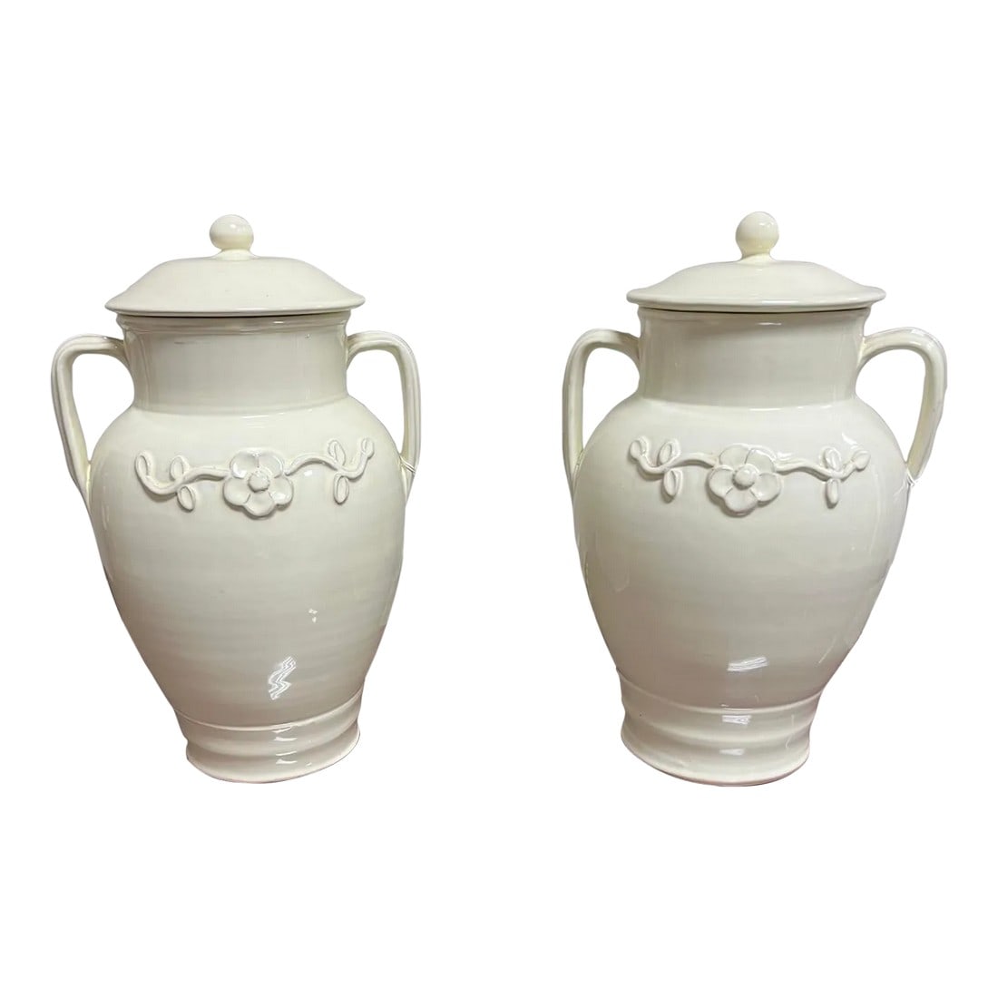 Late 20th Century Global Views Ginger Jars in Cream a Pair: A pair of Global Views urns with lids in an off-white creamy color. Simple flower design on the front. Simple, yet very elegant urns. Made in Italy and sold by Neiman Marcus. Condition: