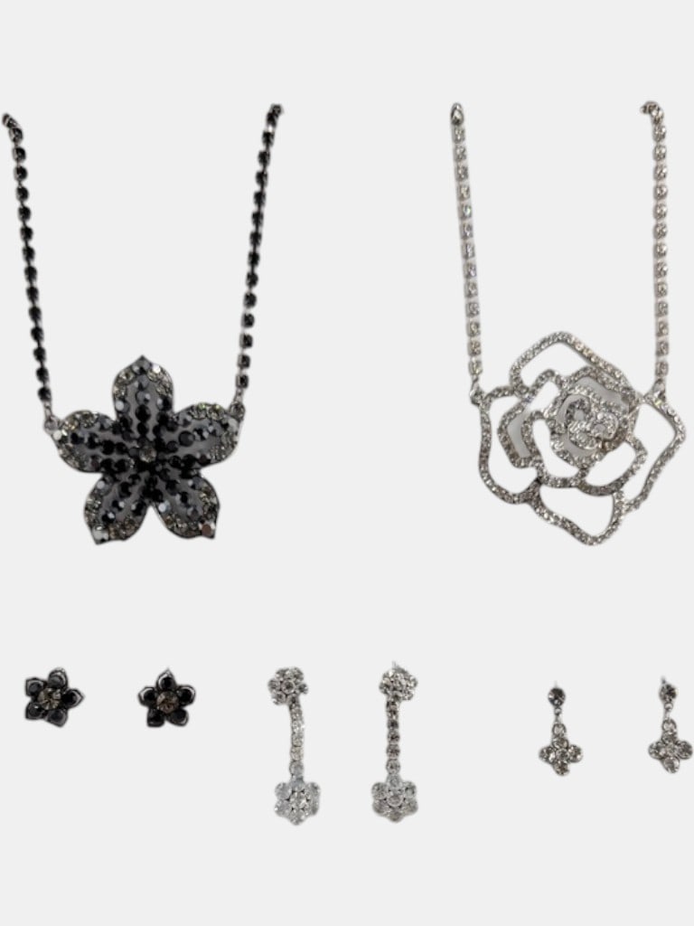 A Collection of Costume Jewelry Necklaces and Earrings: This collection of costume jewelry includes two necklaces and multiple pairs of earrings, all featuring sparkling rhinestones set in silver-tone metal. One necklace features a large, dark-colored