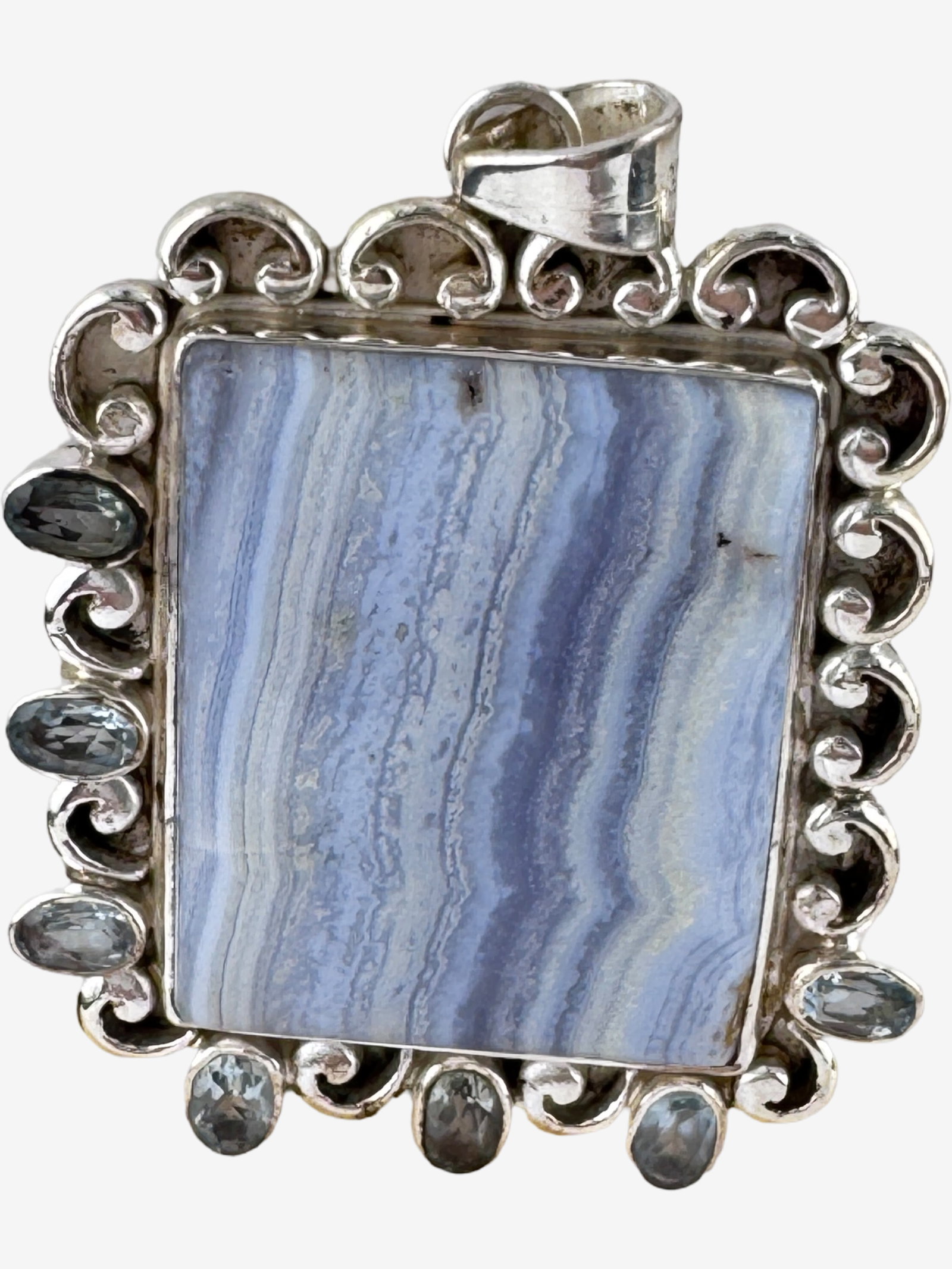 Vintage Sterling Silver Blue Lace Agate Pendant w/ Blue Stone Accents Ð Ornate Statement Piece: A striking sterling silver pendant featuring a large, rectangular cabochon of blue lace agate at its center, exhibiting characteristic delicate banding in shades of light to medium blue. The agate is
