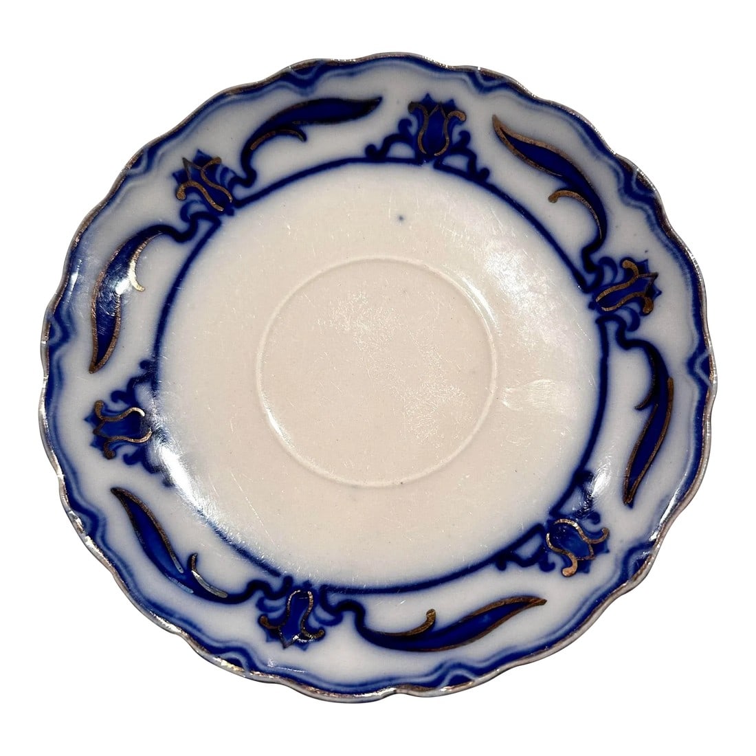 Antique Grindley Lotus Flow Blue Saucer, England: Lotus by W.H. Grindley Antique flow blue saucer -scalloped edging. Motif of lotus flowers and long slim leaves around the rim. Gilded edge and gilding on motif. 5.75" round saucer Made in England Earl