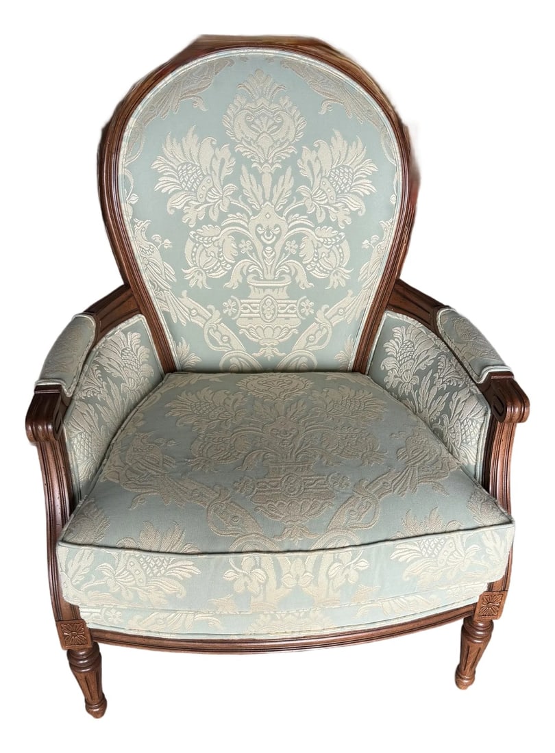 Late 19th Century Louis XVI Style Berger'e Armchair: This chair displays a classic Louis XVI style, as evident in its elegant lines, oval backrest, and carved details on the frame, which likely dates to the late 19th century as a revival piece. This