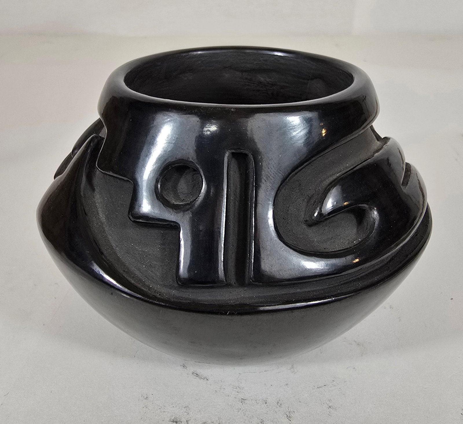 Santa Clara signed pottery jar: Title: Santa Clara signed pottery jarDimension: 3.5" tall x 4.75" diameterDescription: Santa Clara Pueblo blackware pottery jar with deeply carved bird style decoration. Signed Teresita Naranjo