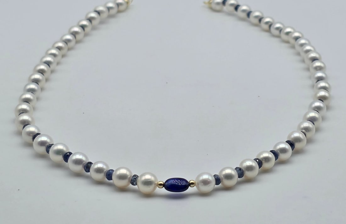 Akoya pearl necklace, 6.2 to 6.4 mm, with natural sapphire spacers, a central oval sapphire with: Title:Akoya pearl necklace, 6.2 to 6.4 mm, with natural sapphire spacers, a central oval sapphire with spheres and an 18kt (750) gold clasp Description:Akoya pearl necklace, 6.2 to 6.4 mm, with natura