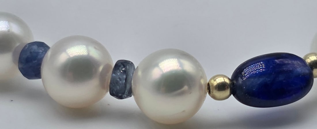 Akoya pearl necklace, 6.2 to 6.4 mm, with natural sapphire spacers, a central oval sapphire with - 7