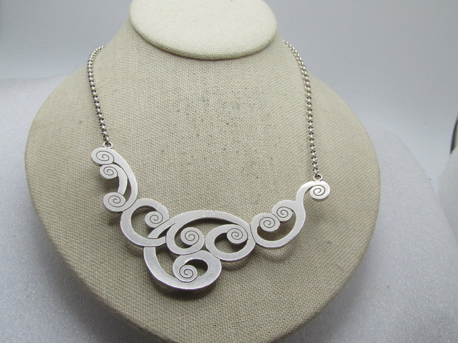 Vintage Brighton Scrolled Rhinestone Bib Necklace, 18", 1980's-1990's: Vintage Brighton Scrolled Rhinestone Bib Necklace, 18", 1980's-1990's. Textured silver tone scrolls make-up the bib that is appx. 4" across the neck and drops down appx. 2.5" from the point that is