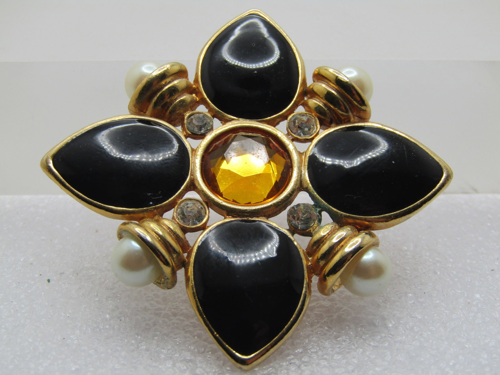 Vintage Black/Yellow/Clear & Pearl Brooch, 1980's, 1.75": Vintage Black/Yellow/Clear & Pearl Brooch, 1980's, 1.75". The black inlaid acrylic bezel-set petals are set on a point creating a cross-like design with concentric gold tone stacked rings with a round