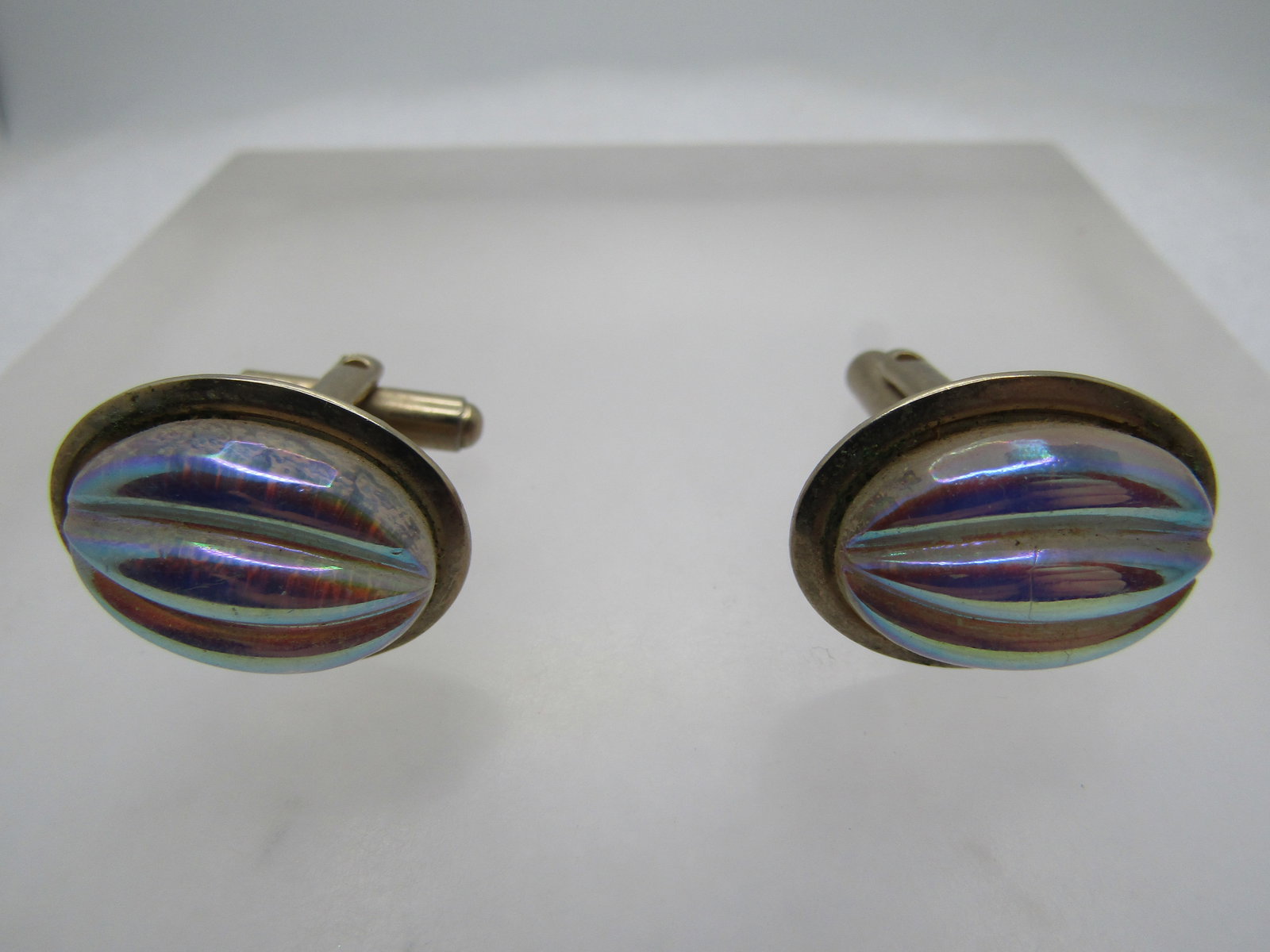 Vintage Iridescent Glass Cufflinks, 1950's-1960's: Vintage Iridescent Glass Cufflinks, 1950's-1960's. Oval gold tone setting that holds a triple ridged glass aurora borealis iridescent glass stone that is oval and appx. 18mm by 13mm. Gold tone